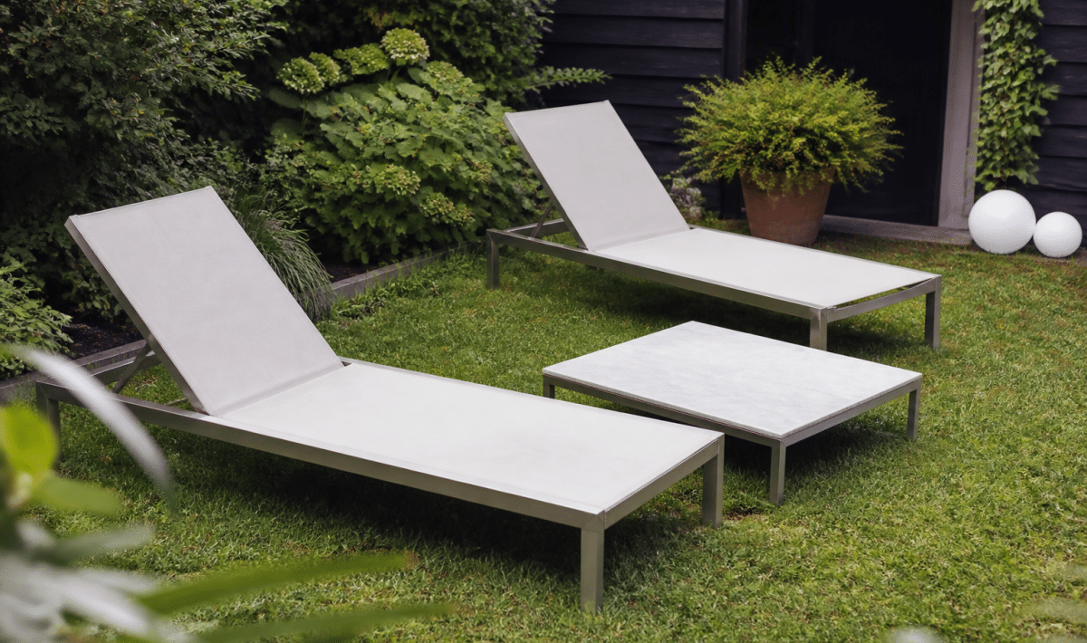 Chaises longues et table basse installes sur terrasse gazon